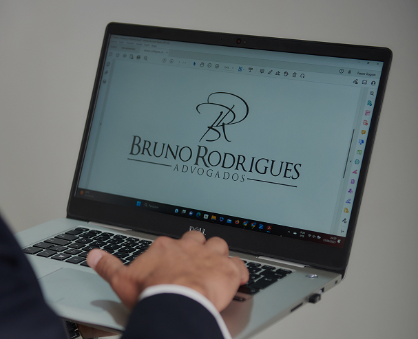 Foto de um colaborador segurando laptop mostrando a logo de Bruno Rodrigues